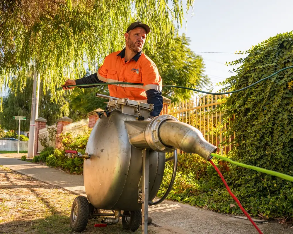 A Pipe Relining Perth technician operating an inversion drum on site.