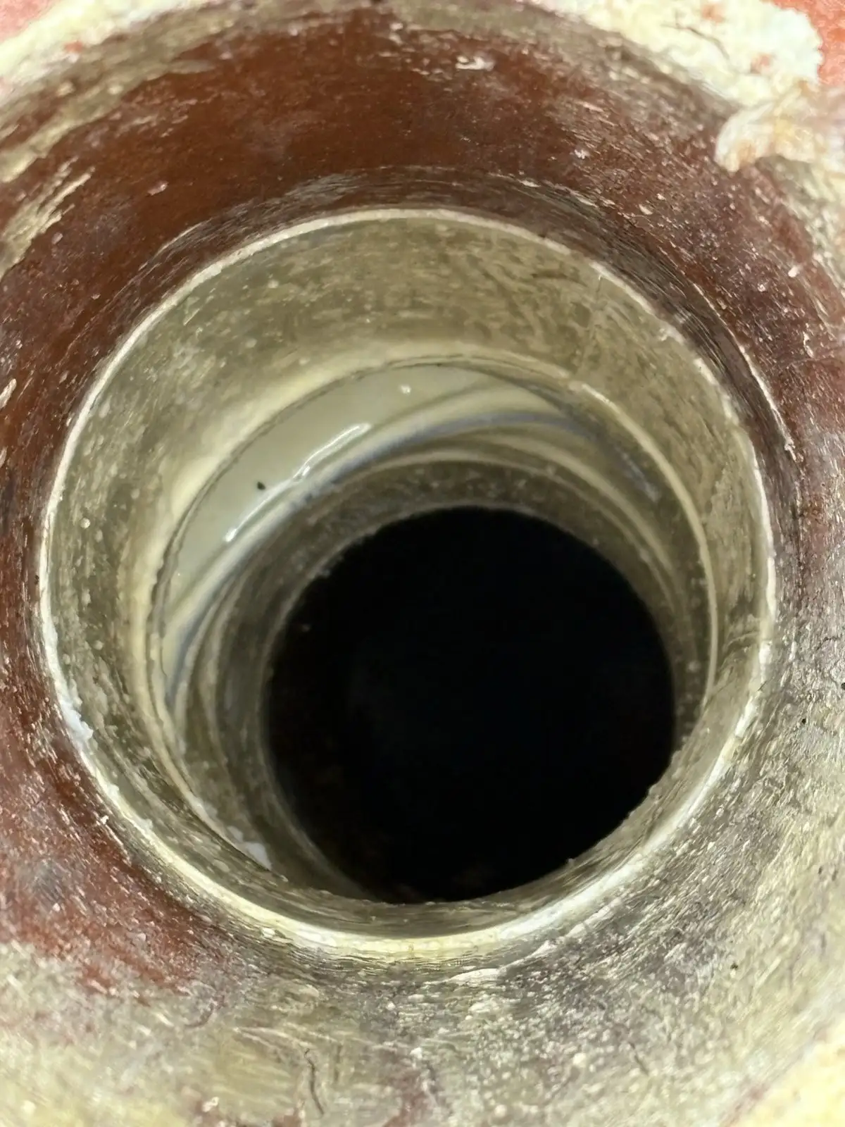 Looking down the Edgewater inspection shaft after relining, with the new liner visible inside the old pipe.