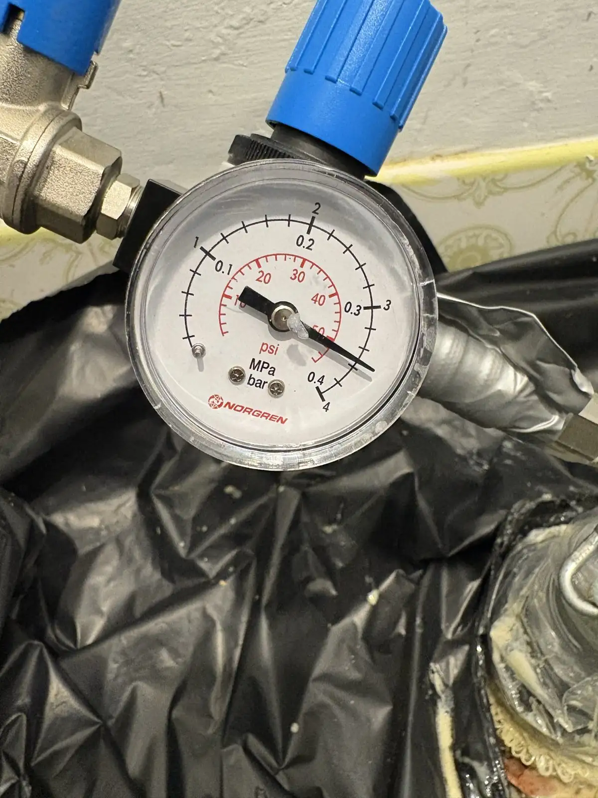 A pressure gauge on the relining rig at a Rockingham home, set over the sealed toilet opening while the liner cures.